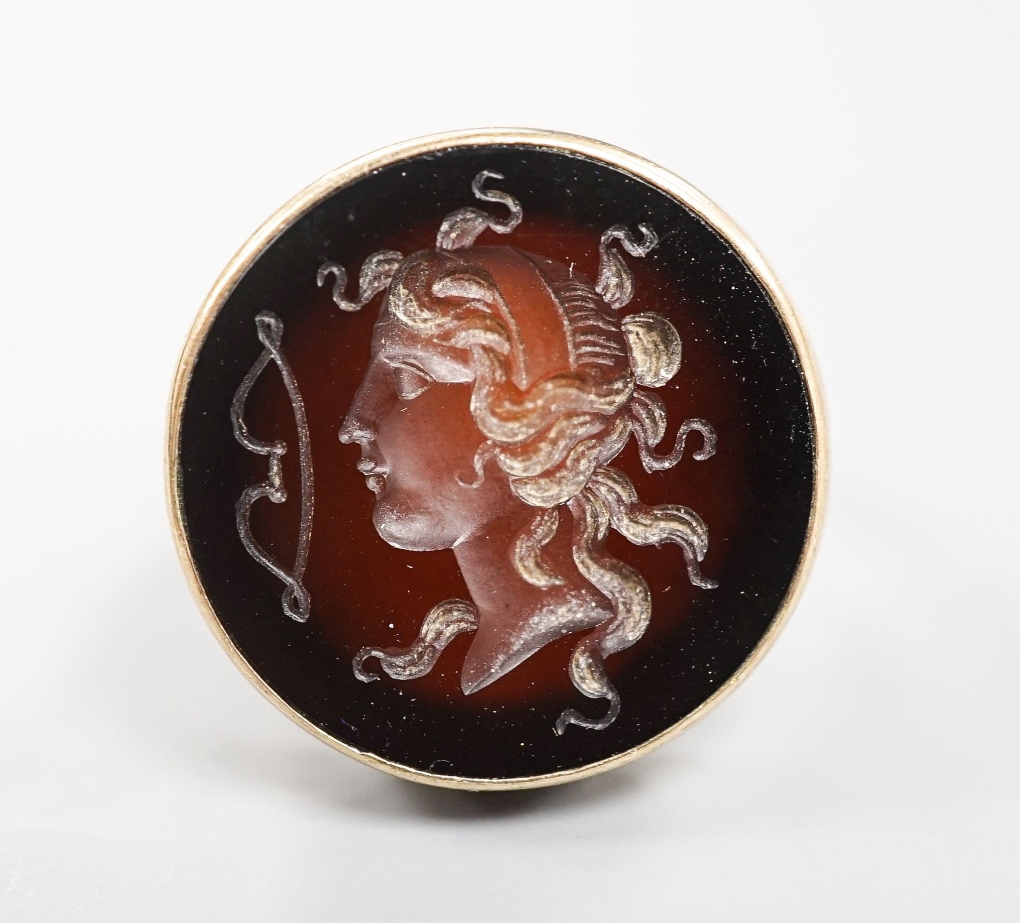 An early 20th century 9ct and intaglio brown chalcedony set ring, carved with the bust of a lady to dexter, size Q, gross weight 8.4 grams.